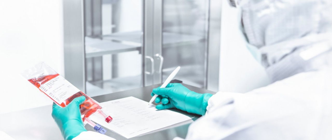 Pharmazeut im Reinraumlabor mit einem Infusionsbeutel in der Hand